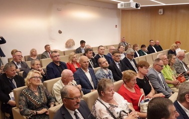Uczestnicy konferencji siedzą w sali konferencyjnej