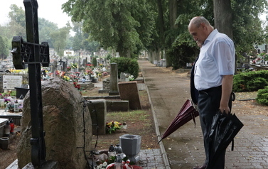 Wiceburmistrz oraz zasłaniający go pan Leśniewski skłaniają głowy przed obeliskiem.