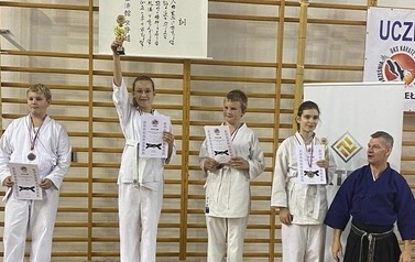 Zawodnicy na podium z puchami i medalami.