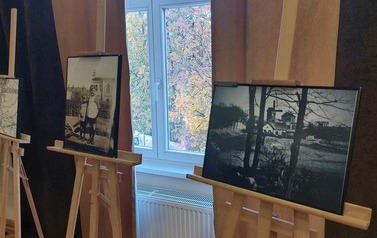 Trzy historyczne zdjęcia prezentowane na drewnianych sztalugach. Na pierwszym fragment cmentarza żydowskiego w Trzemesznie, na drugim dw&oacute;ch chłopc&oacute;w, na trzecim fragment macewy.