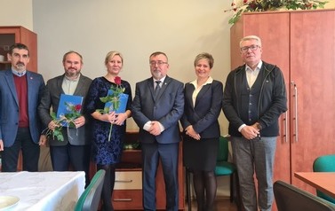 Dwoje nagrodzonych nauczycieli i ich dyrektor pozują do zdjęcia z samorządowcami.