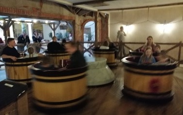 Widok na karuzelę. dzieci i dorośli siedzą w kręcących się baliach.
