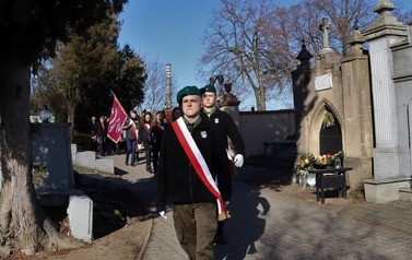 Poczty maszerujące aleją na cmentarzu.