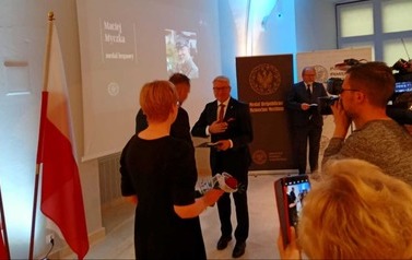 Przewodniczący komitetu odbiera medal podczas uroczystej gali.