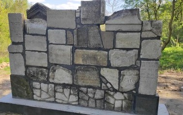 Pomnik - ściana utworzona z zespolonych fragment&oacute;w macew.