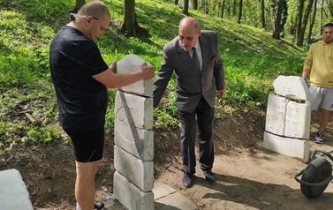 Trzech mężczyzn podczas prac umieszczania macew na cmentarzu.
