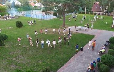 Widok z g&oacute;ry na rekreacyjny plac, na kt&oacute;rym ćwiczą zawodnicy.