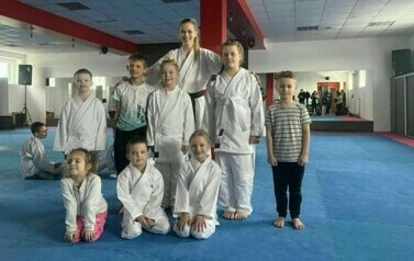 Zawodnicy w strojach karate pozują do zdjęcia.
