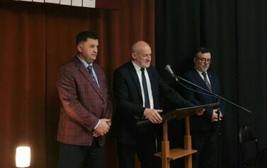 Przy m&oacute;wnicy stoją burmistrz, przewodniczący rady miejskiej i przewodniczący rady pożytku.