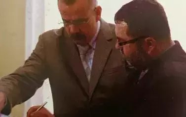 dwie osoby podpisują dokument 