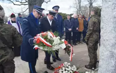 trzy osoby w mundurach, wiązanka kwiat&oacute;w 