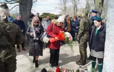 dwie osoby, wiązanka kwiat&oacute;w, cmentarz