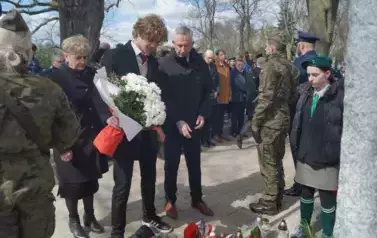 trzy osoby, wiązanka kwiat&oacute;w cmentarz