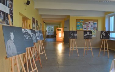 Wystawa fotografii Marcelego Koniecznego. Zdjęcia umieszczone na drewnianych sztalugach ustawionych na korytarzu szkolnym.