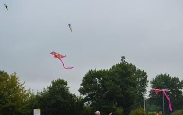 Dzieci z opiekunami puszczają latawce
