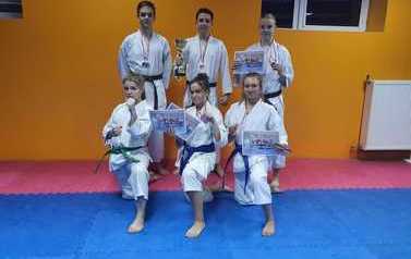 Zawodnicy AKT Samuraj Gniezno pozują na macie z dyplomami i medalami