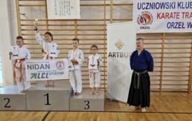 Zawodnicy na podium z puchami i medalami.