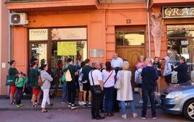 Grupa z przewodnikiem przed domem z tablicą pamiątkową jednego z obrońc&oacute;w Trzemeszna.