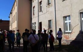 Grupa z przewodnikiem przy tylnej ścianie budynku dzisiejszego urzędu.