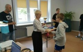kobieta wręcza dziecku puchar