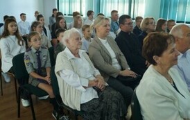 duża grupa os&oacute;b siedzących na sali