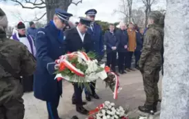 trzy osoby w mundurach, wiązanka kwiat&oacute;w 