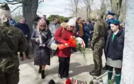 dwie osoby, wiązanka kwiat&oacute;w, cmentarz