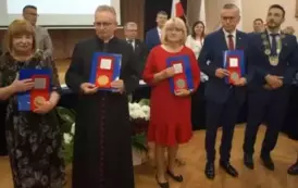 grupa pięciu os&oacute;b z medalami 